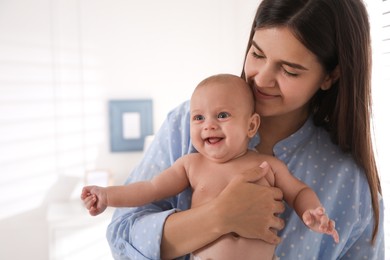 Happy young mother with her cute baby at home