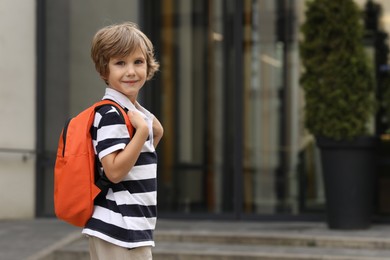 Photo of Portrait of little boy near kindergarten outdoors. Space for text