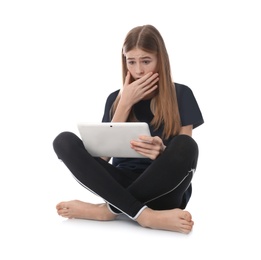 Photo of Shocked teenage girl with tablet on white background. Danger of internet