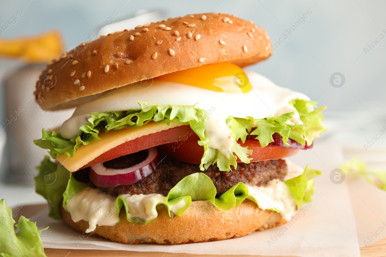 Photo of Tasty burger with fried egg on wooden board