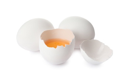 Photo of Cracked and whole chicken eggs on white background