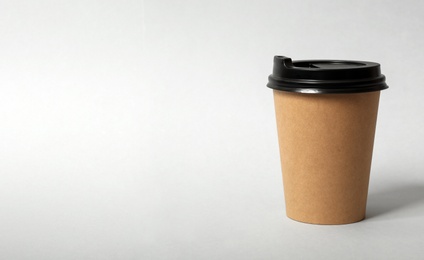 Photo of Takeaway paper coffee cup on light grey background. Space for text