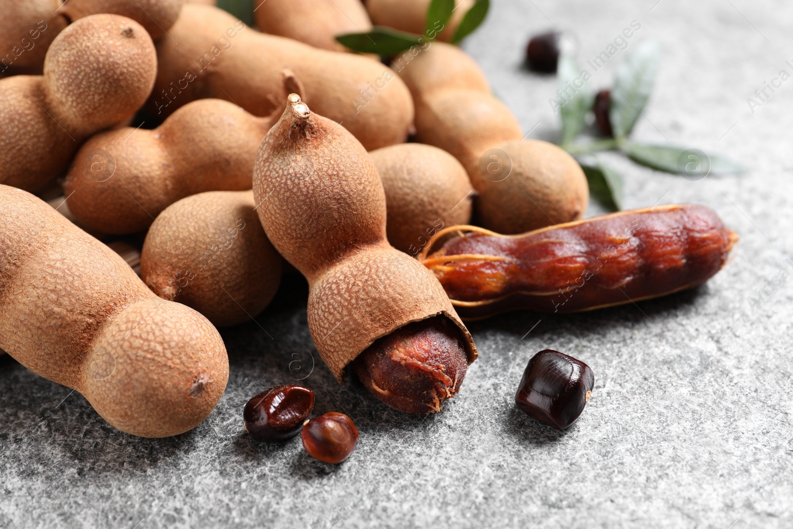 Photo of Delicious ripe tamarinds on grey table, closeup