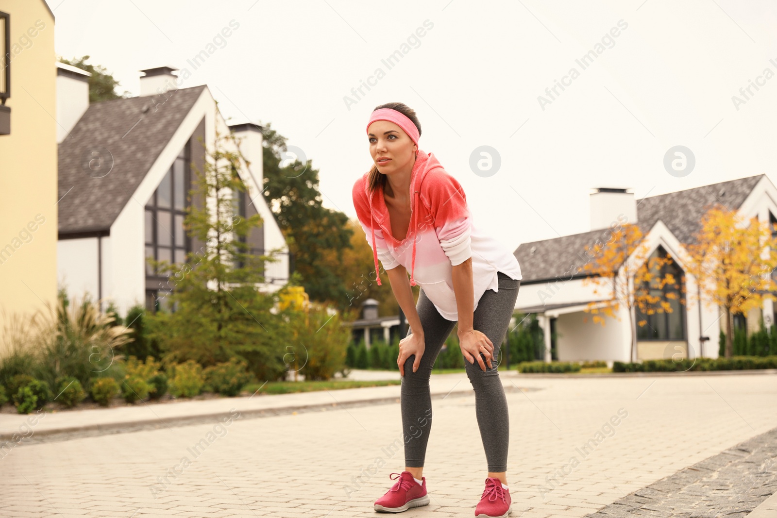 Photo of Beautiful sporty woman resting after running on street. Healthy lifestyle