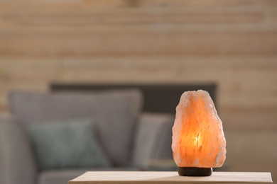 Himalayan salt lamp on table against blurred background