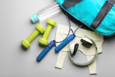 Flat lay composition with gym bag and sportswear on light grey background