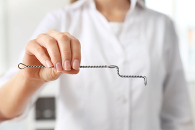 Speech therapist with logopedic probe in clinic, closeup