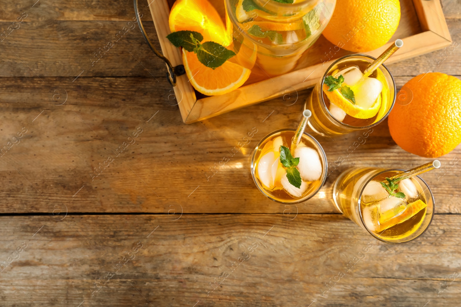 Photo of Delicious refreshing drink with orange slices on wooden table, flat lay. Space for text