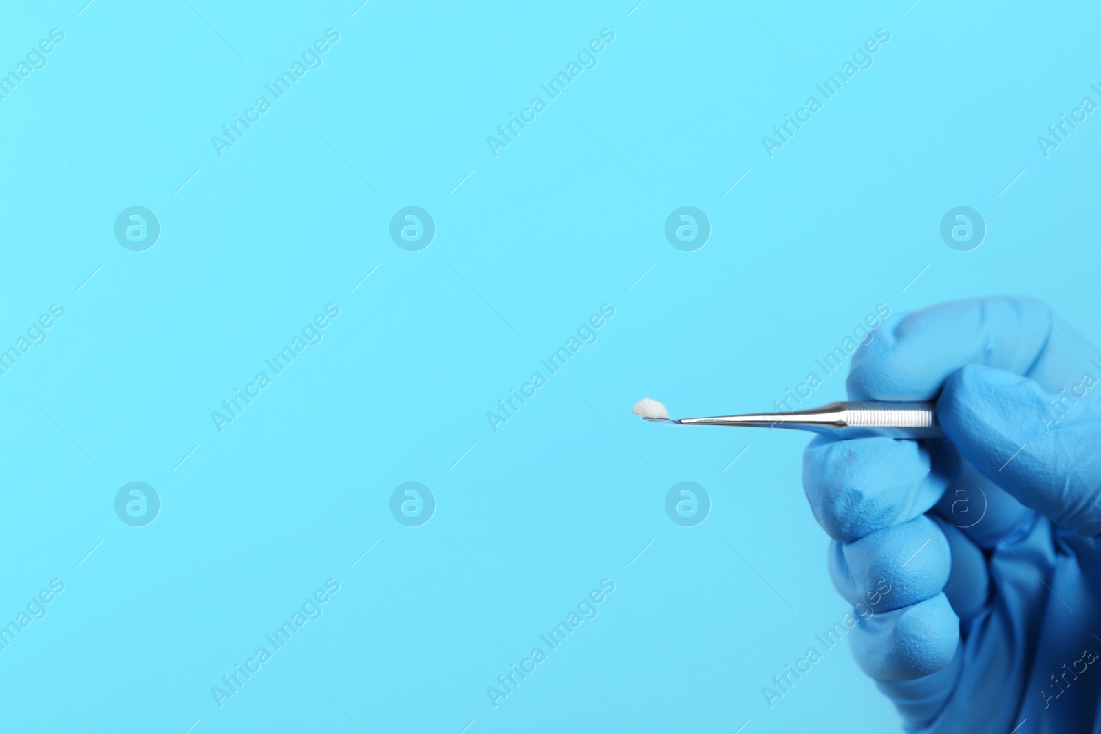 Photo of Dentist holding professional instrument on color background, space for text. Mouth and teeth care