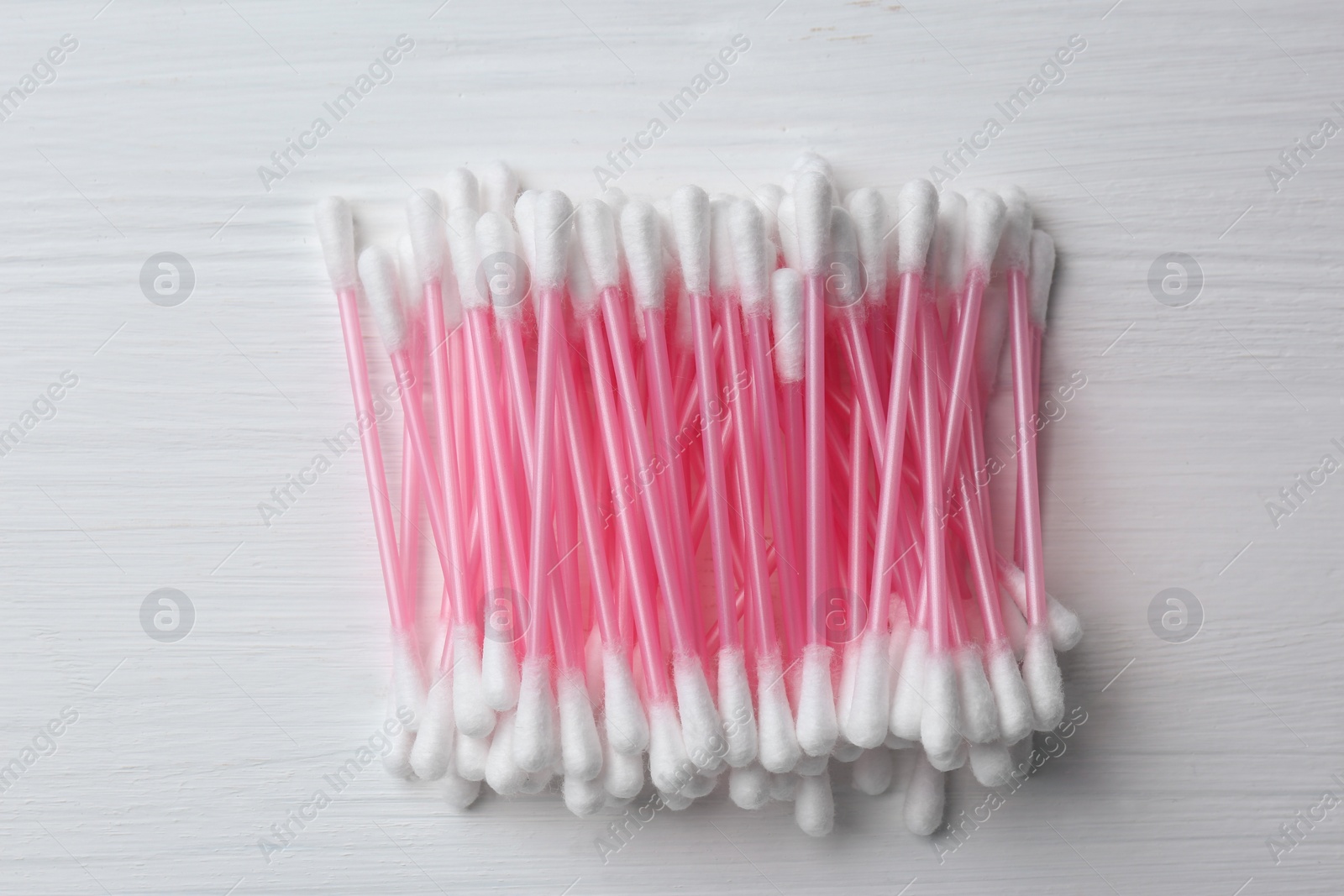 Photo of Many cotton buds on white wooden table, flat lay