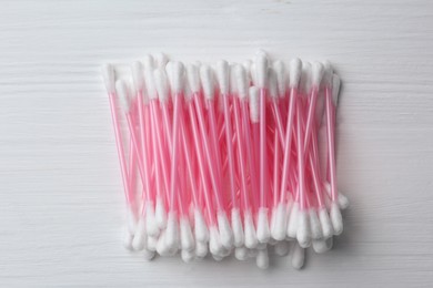 Photo of Many cotton buds on white wooden table, flat lay