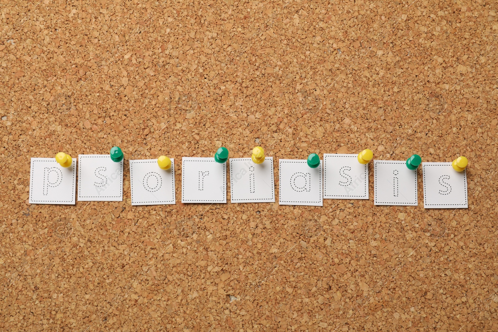 Photo of Word Psoriasis made of paper letters pinned to cork board, top view