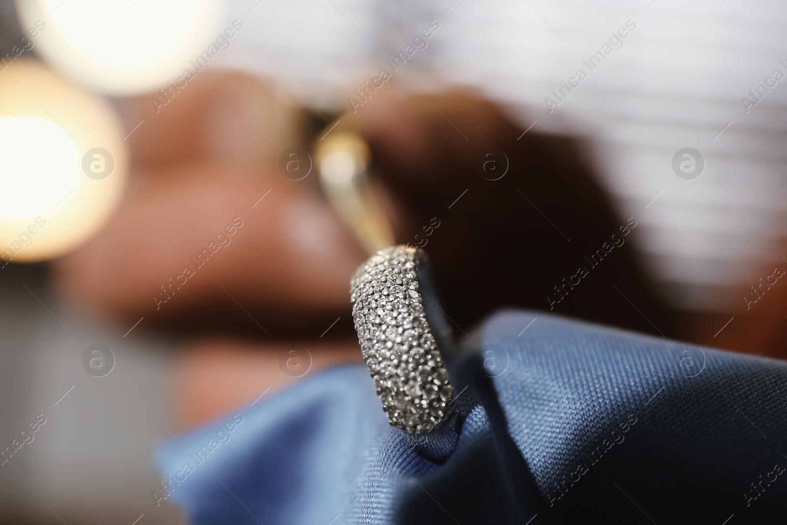 Photo of Professional jeweler working with beautiful ring indoors, closeup