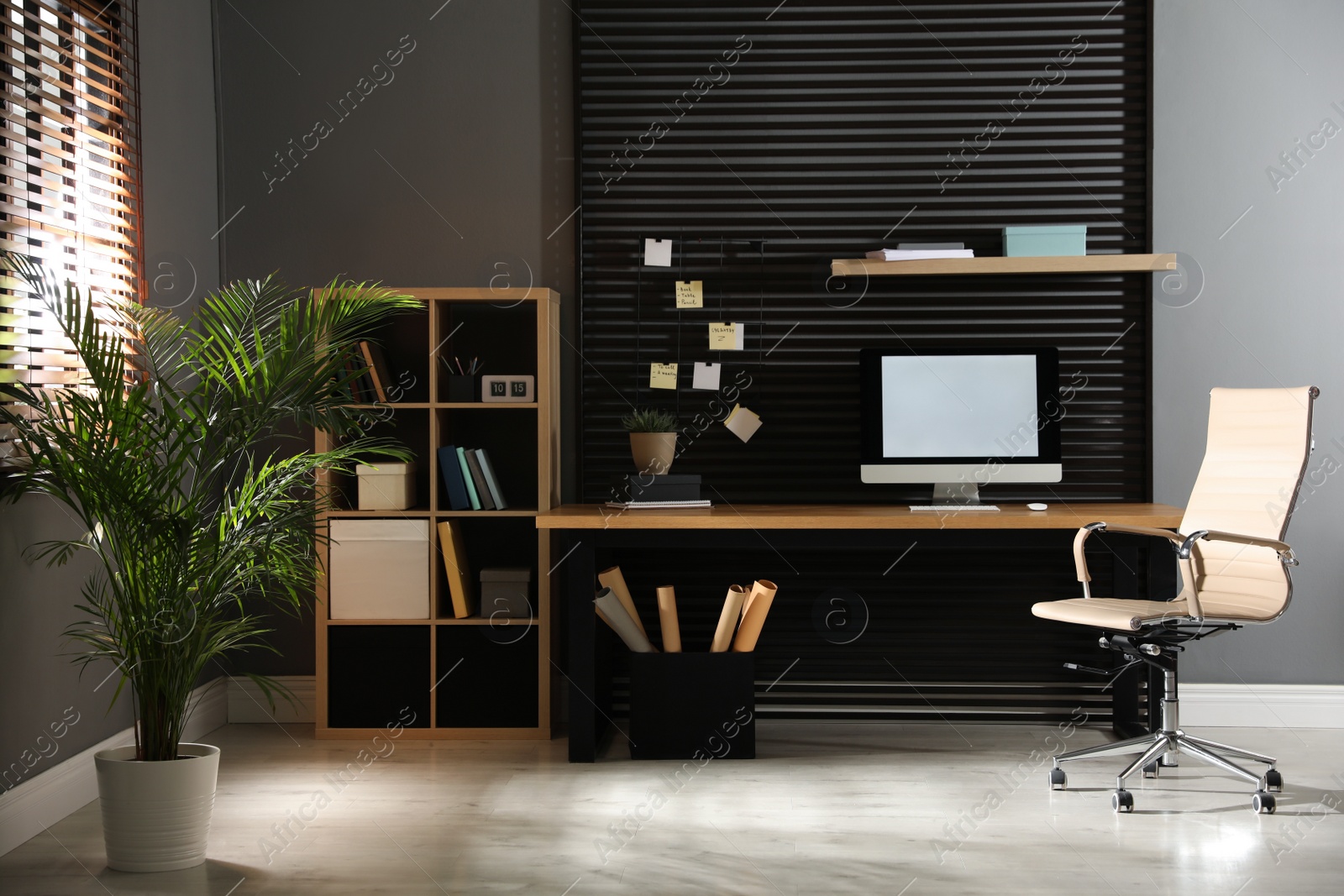 Photo of Comfortable workplace with computer and office chair. Stylish room interior