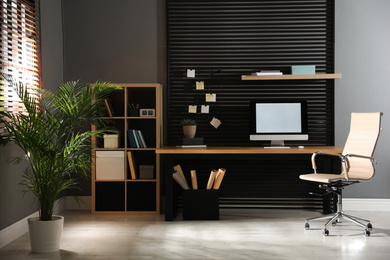 Comfortable workplace with computer and office chair. Stylish room interior