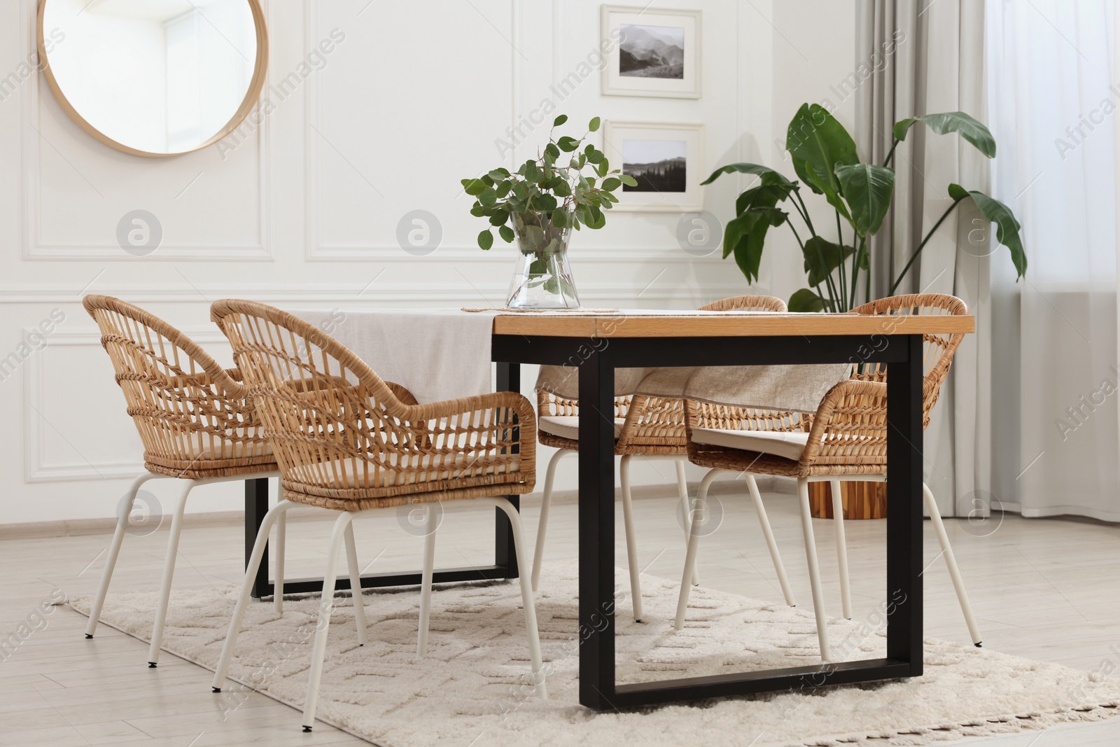 Photo of Stylish dining room with cozy furniture, mirror and plants