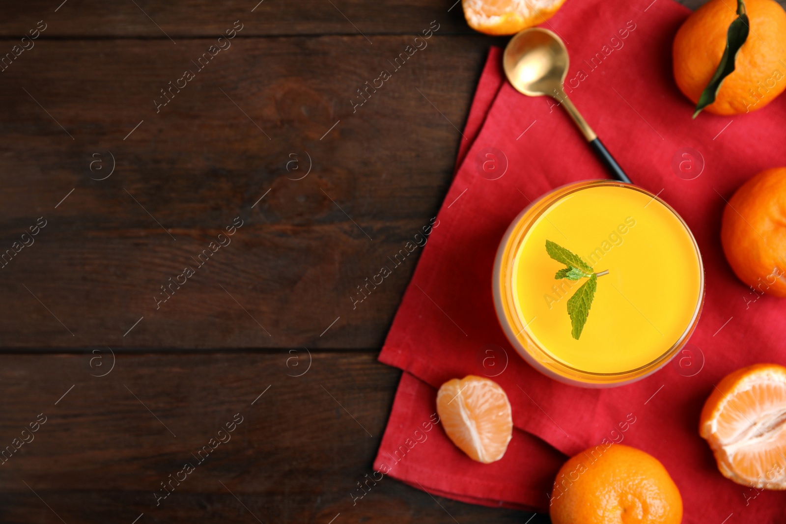 Photo of Delicious tangerine jelly and fresh fruits on brown wooden table, flat lay. Space for text