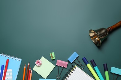 Photo of Flat lay composition with golden bell and school stationery on green chalkboard, space for text