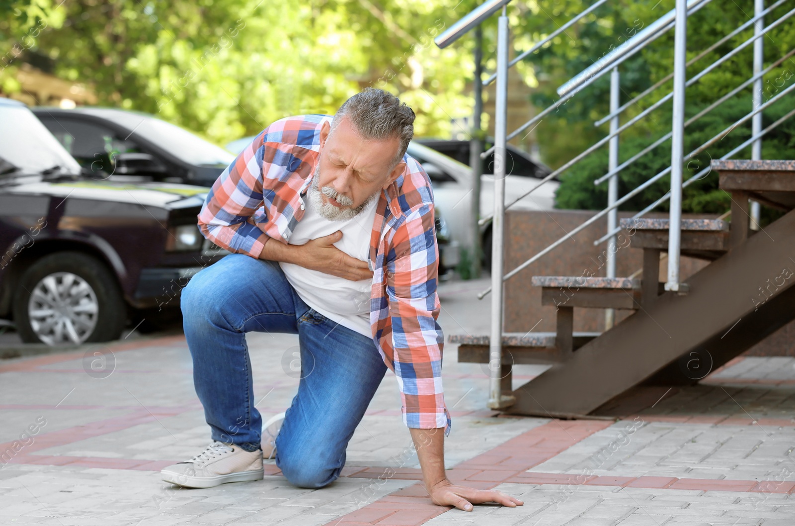 Photo of Mature man having heart attack, outdoors