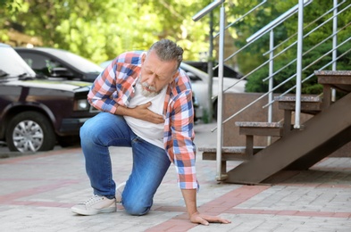 Mature man having heart attack, outdoors