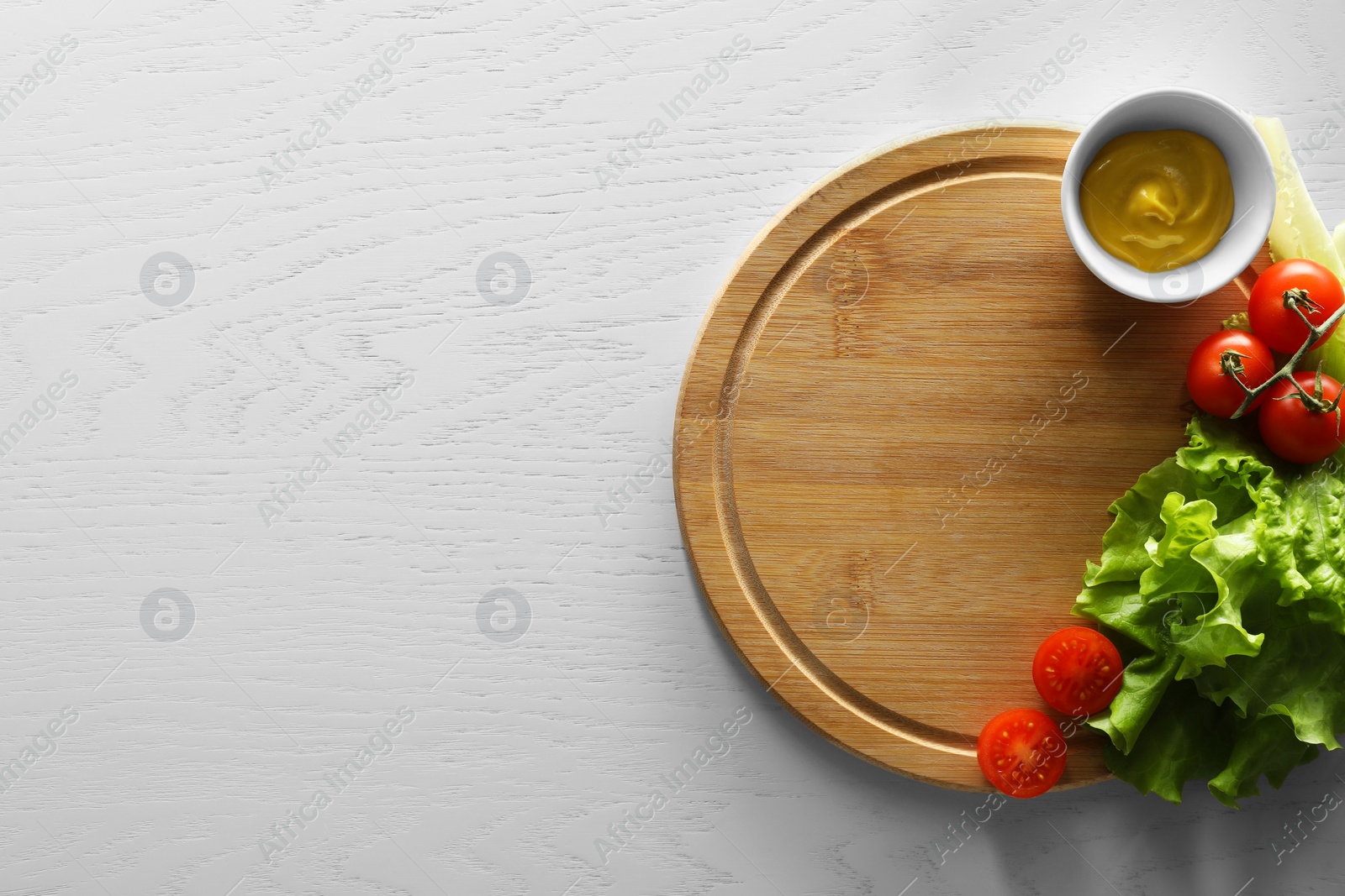 Photo of Food photography. Fresh cherry tomatoes, mustard and lettuce on white wooden table, top view with space for text