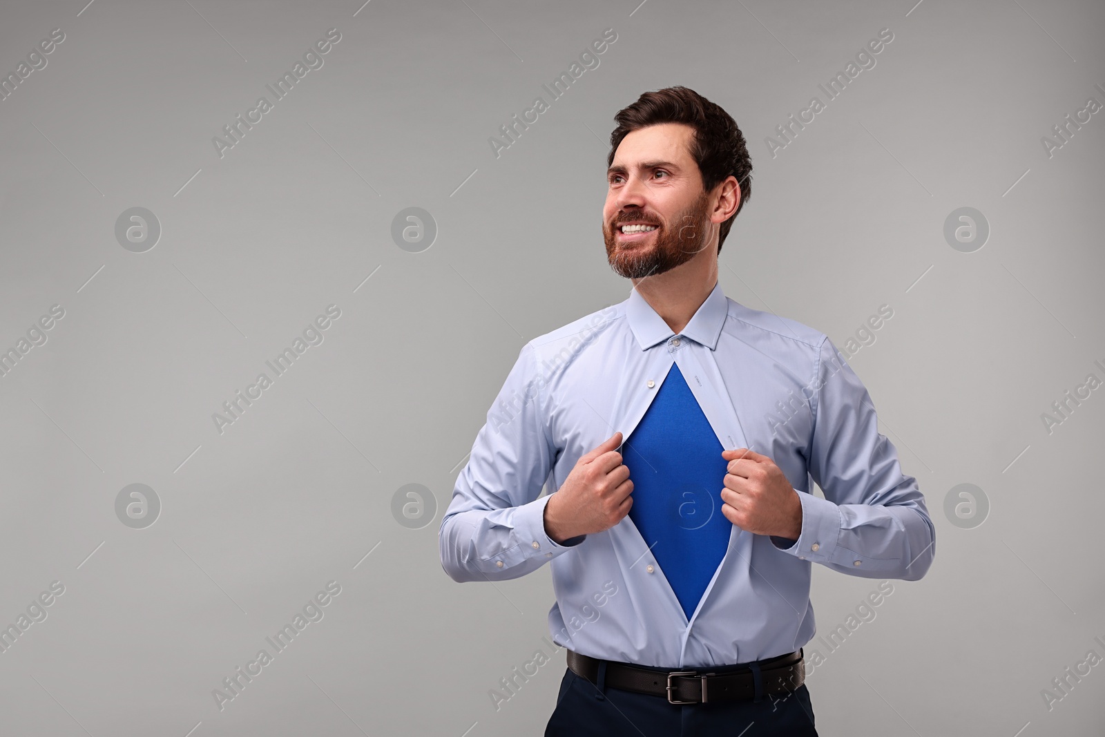 Photo of Happy businessman wearing superhero costume under suit on beige background. Space for text