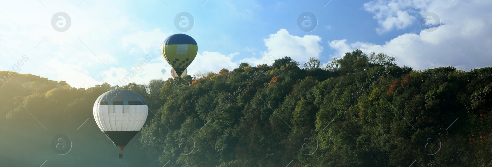 Image of Hot air balloons near forest, space for text. Banner design 