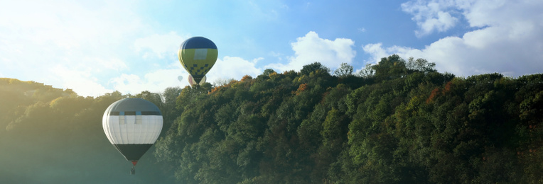 Hot air balloons near forest, space for text. Banner design 