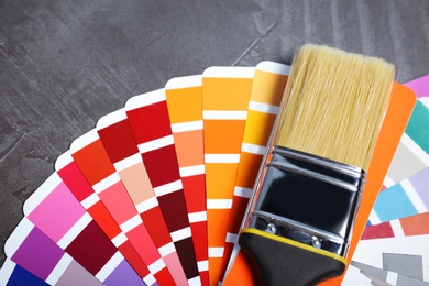 Photo of Brush and paint color palette samples on gray background, closeup