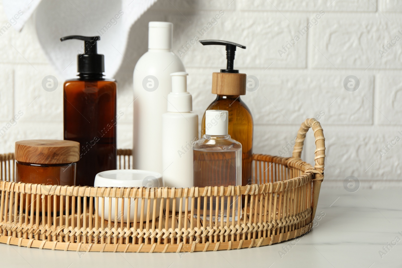 Photo of Bath accessories. Personal care products on white table near brick wall