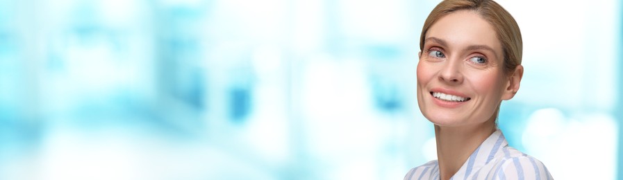 Image of Woman with clean teeth smiling on blurred background, space for text. Banner design