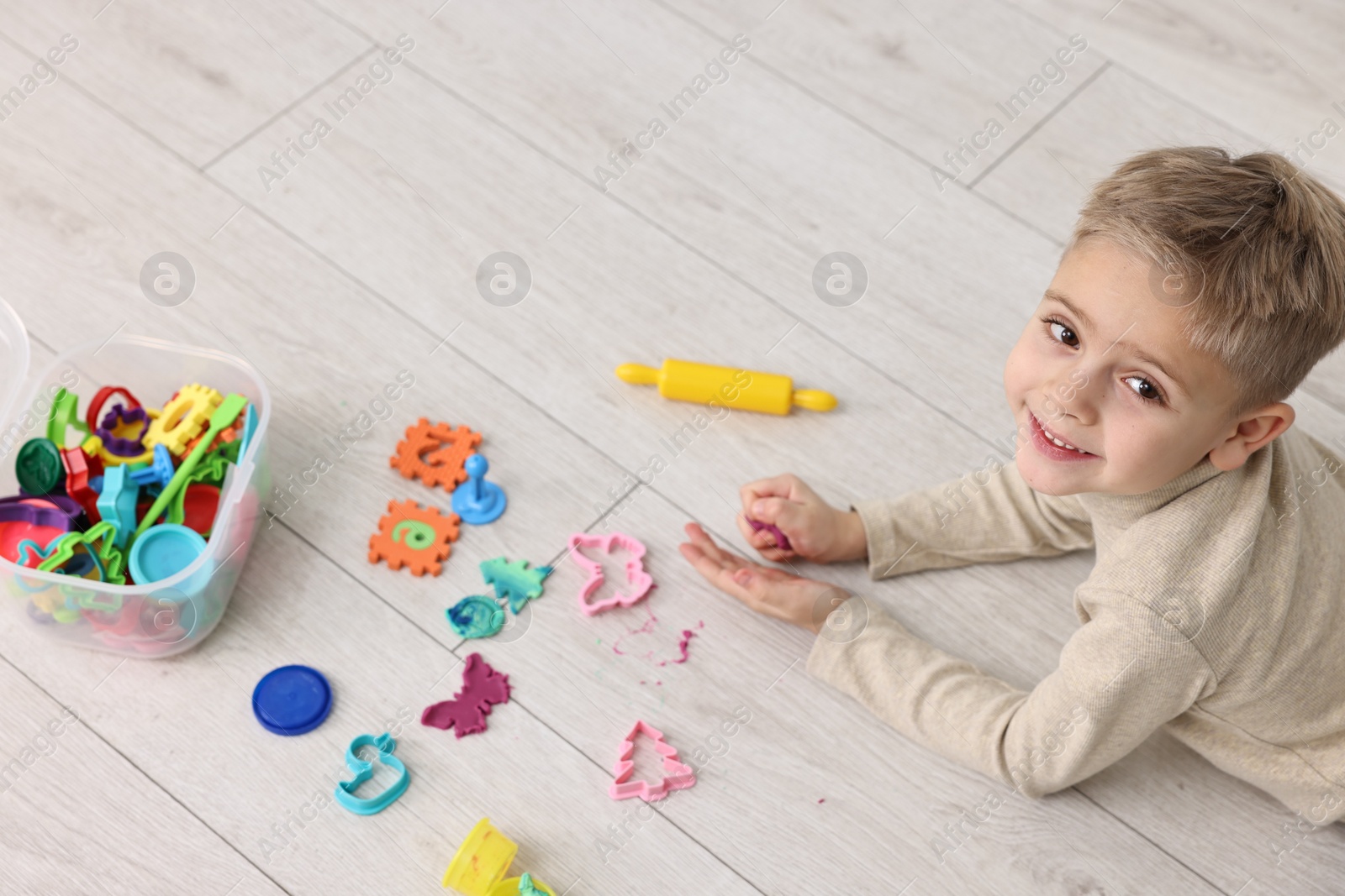 Photo of Cute little boy playing on warm floor indoors. Heating system