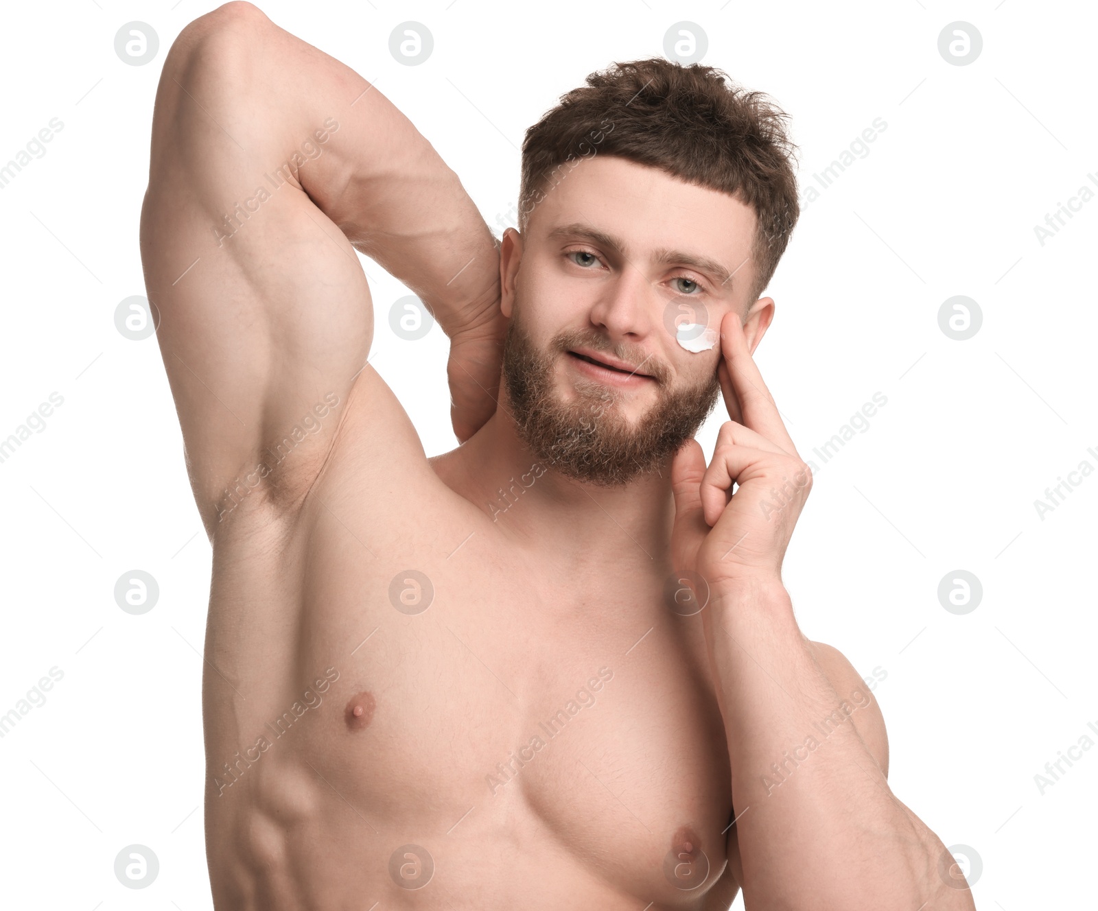 Photo of Handsome man applying moisturizing cream onto his face on white background