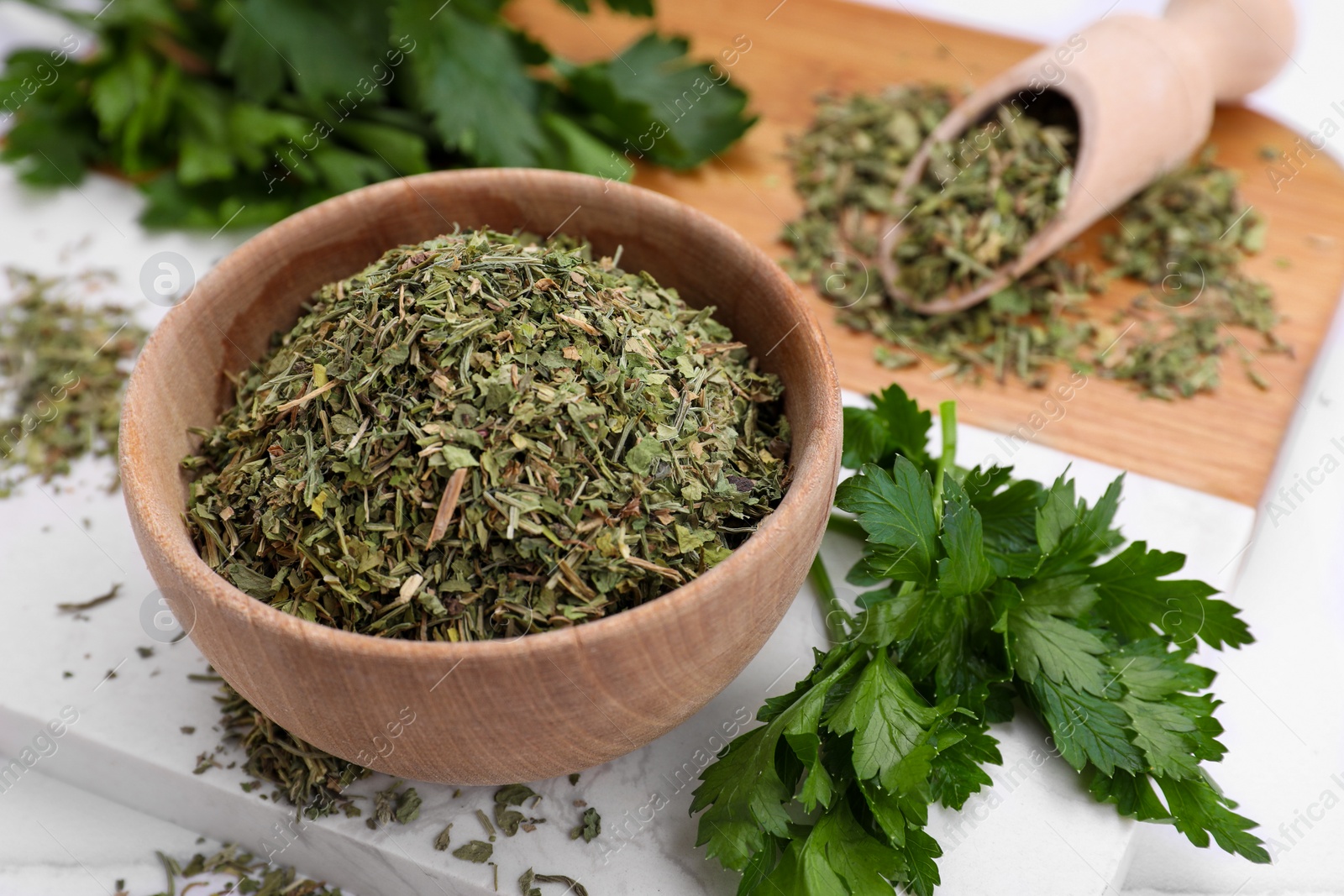 Photo of Dried parsley and fresh leaves on table, closeup