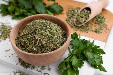 Photo of Dried parsley and fresh leaves on table, closeup