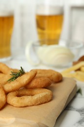 Photo of Fried onion rings served on white marble table