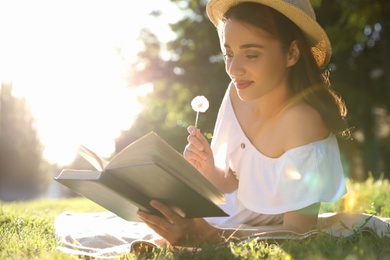 Photo of Beautiful young woman reading book in park