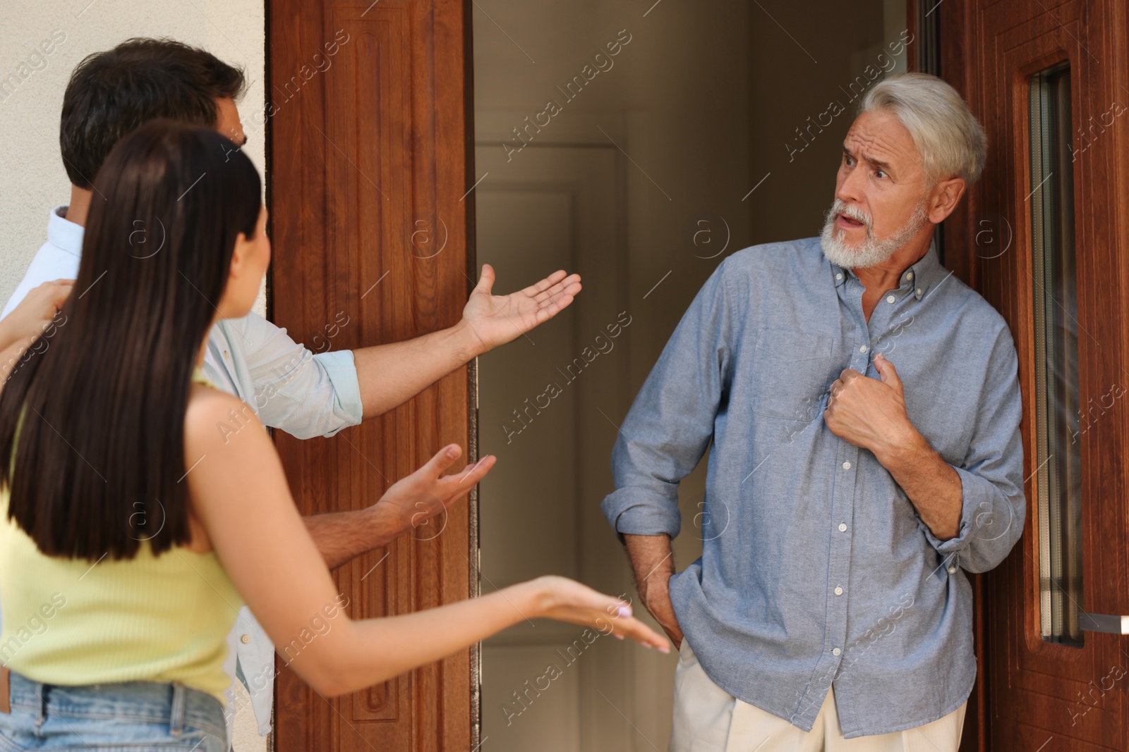 Photo of Neighbour`s quarrel. Young couple arguing with emotional senior man