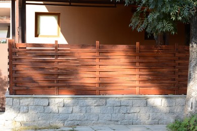 Photo of Wooden fence near house on sunny day outdoors