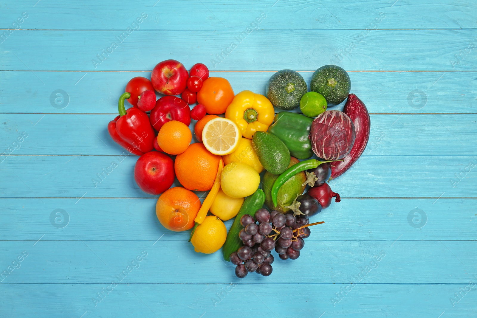 Photo of Rainbow heart made of fruits and vegetables on wooden background