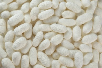 Photo of Pile of natural silkworm cocoons as background, closeup