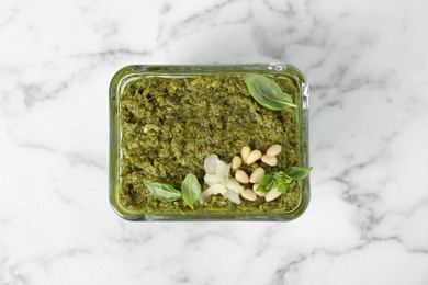 Photo of Delicious pesto sauce in bowl on white marble table, top view