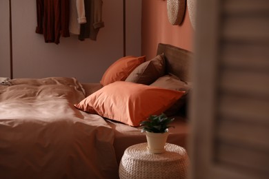 Bed with orange and brown linens in stylish room