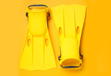 Photo of Pair of flippers on yellow background, flat lay