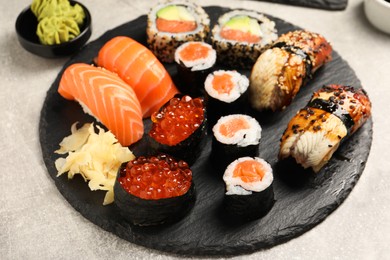 Set of delicious sushi rolls on light grey table