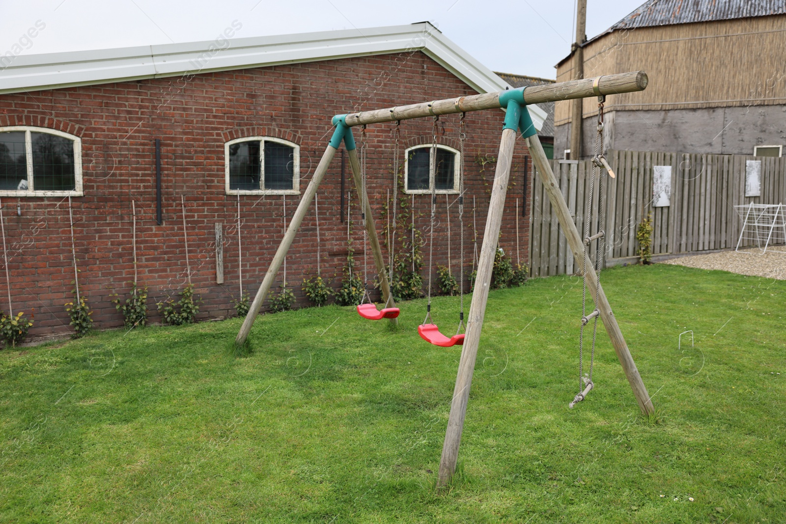 Photo of Spacious backyard with swing set on spring day