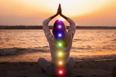 Young woman meditating on beach near river at sunset, back view. Scheme of seven chakras, illustration