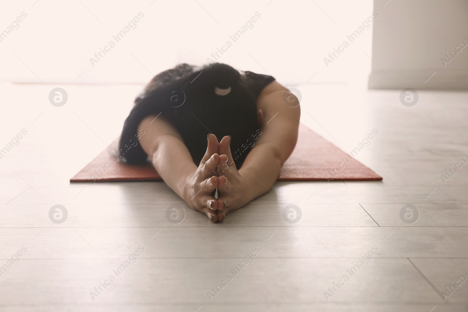 Photo of Young woman practicing relaxation pose in yoga studio, closeup