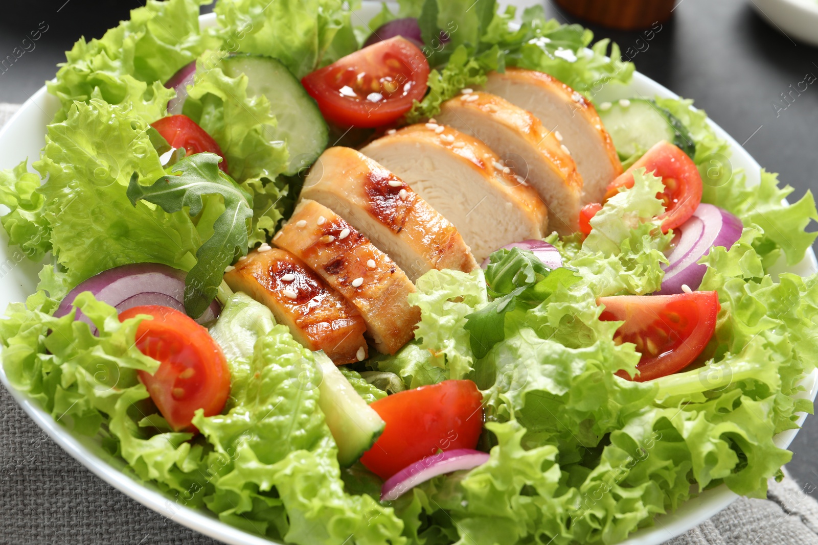 Photo of Delicious salad with chicken and vegetables on table, closeup