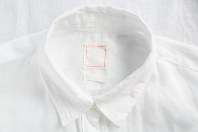 Blank clothing labels on white shirt, top view